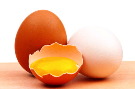 Fresh chicken eggs on wooden board over white backgroundの写真素材