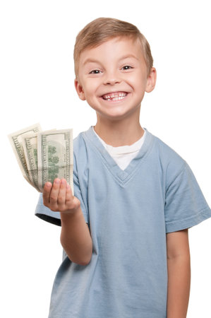 Portrait of a cheerful little boy holding a dollars over white backgroundの写真素材