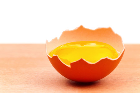 Fresh chicken egg on wooden board over white background