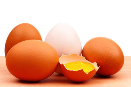 Fresh chicken eggs on wooden board over white backgroundの写真素材