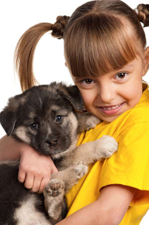 Portrait of little girl with cute puppy isolated on white backgroundの写真素材