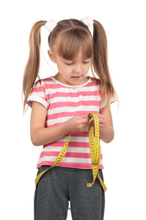 Portrait of little girl with yellow measure over white backgroundの写真素材