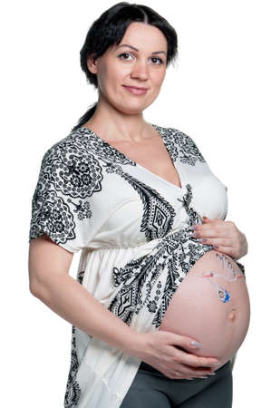 Tummy of pregnant woman with funny drawing over white backgroundの写真素材