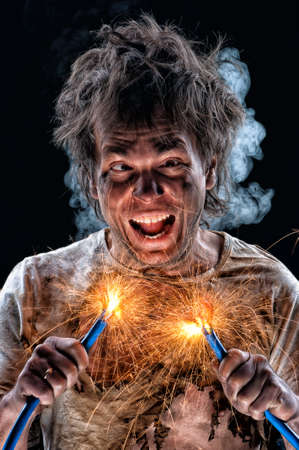 Portrait of crazy electrician over black backgroundの写真素材