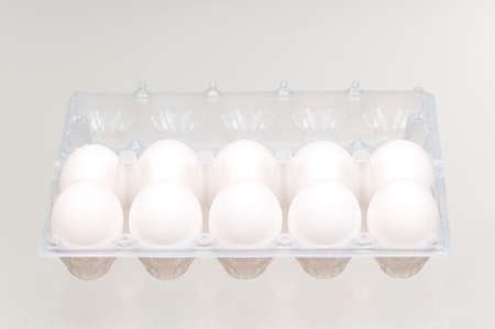 White eggs in the plastic box over white backgroundの写真素材