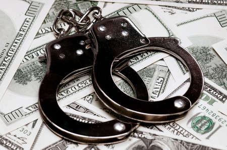 Handcuffs on money background as security conceptの写真素材