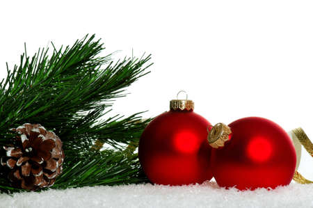 Red christmas baubles with snow on white backgroundの写真素材