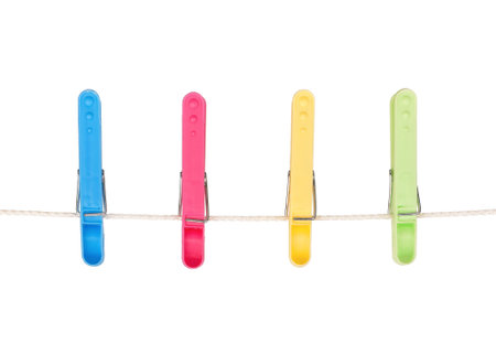 Four colorful clothespins hang on a cord isolated on white background
