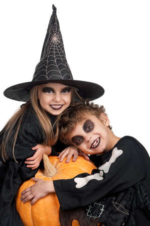 Boy and girl wearing halloween costume with pumpkin on white backgroundの写真素材