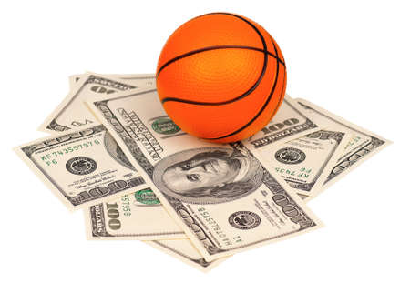 Small basketball ball on heap of dollars isolated on a white backgroundの写真素材