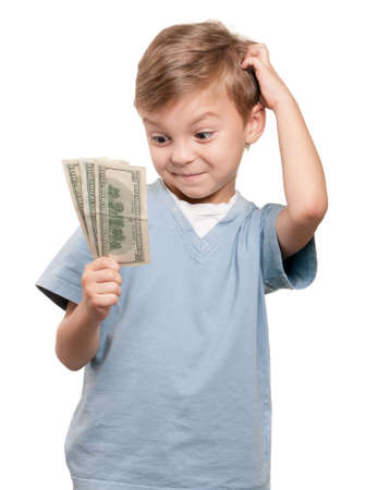 Portrait of a surprised little boy holding a dollars over white backgroundの写真素材