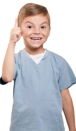 Cheerful little boy pointing up over white background