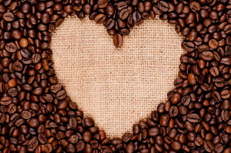 Heart made of coffee beans on the old burlapの写真素材