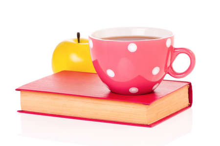 Big mug polka dot of tea and book, isolated on white backgroundの写真素材