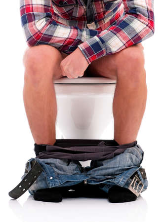 Man is sitting on the toilet bowl, on white backgroundの写真素材