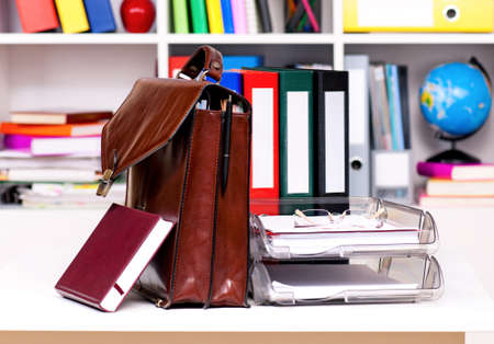 Brown leather briefcase with office accessories, isolated on white backgroundの写真素材