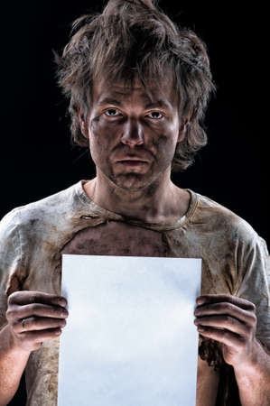 Portrait of funny electrician showing blank placard board over black backgroundの写真素材