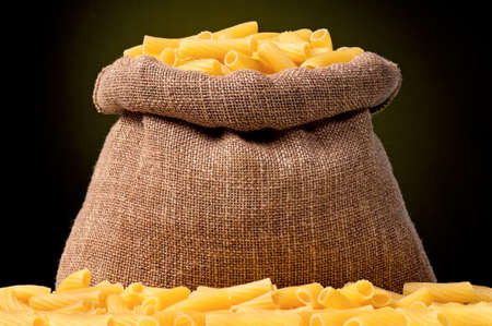 Pasta in bag, on a dark yellow backgroundの写真素材