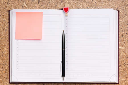 Open notebook with pen on wood background - top viewの写真素材