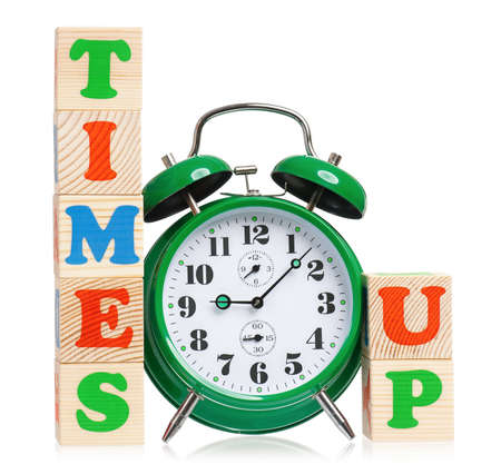Time concept - Big green alarm clock with wooden alphabet blocks, isolated on white backgroundの写真素材