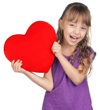 Portrait of little girl holding red heart over white backgroundの写真素材
