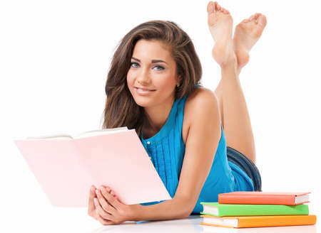 Beautiful student girl with books lying on floor, isolated on white backgroundの写真素材