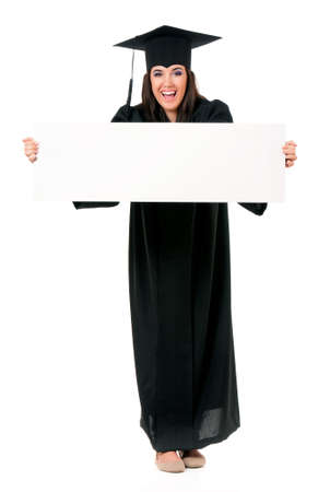 Beautiful graduate girl student in mantle showing blank placard board, isolated on white backgroundの写真素材
