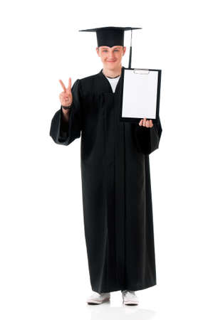 Handsome graduate guy student in mantle showing blank placard board, isolated on white backgroundの写真素材