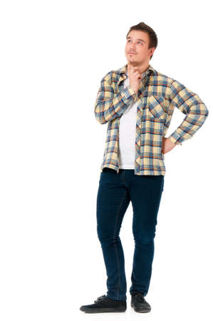 Full length portrait of young man looking thoughtful while holding his head, isolated on white backgroundの写真素材
