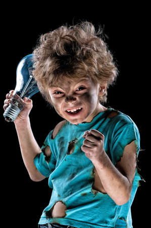Portrait of funny little electrician with lightbulb over black backgroundの写真素材