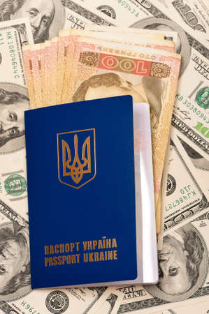 International Ukrainian passport with Hryvna banknotes on US dollars backgroundの写真素材