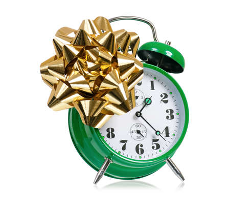 Big green alarm clock with bow, isolated on white backgroundの写真素材
