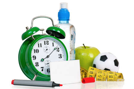 Alarm clock with bottle of water and empty blank paper card sign, isolated on white backgroundの写真素材