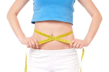 Close up young fitness model with measuring tapeの写真素材