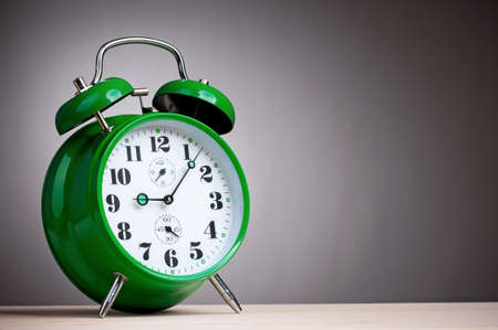 Big green alarm clock on grey backgroundの写真素材