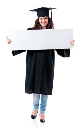 Beautiful graduate girl student in mantle showing blank placard board, isolated on white backgroundの写真素材