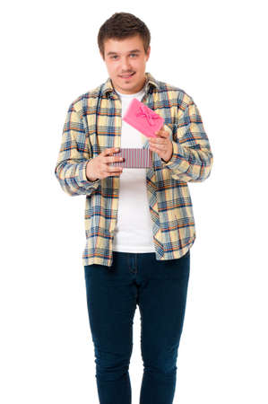 Portrait of young man holding gift, isolated on white backgroundの写真素材