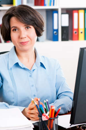 Beautiful business woman at workplace looking at cameraの写真素材