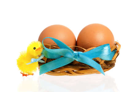 Beautiful little toy chicken and nest with eggs, isolated on white backgroundの写真素材