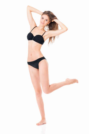 Sexy young woman posing in a black bikini, isolated on white backgroundの写真素材