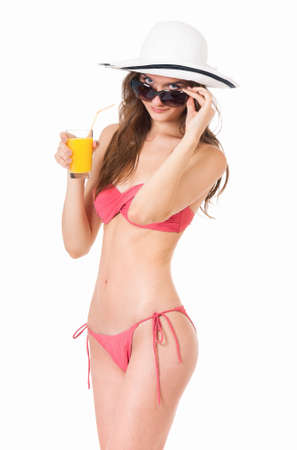 Prett girl posing in bikini summer hat and sunglasses, drink orange juice, isolated on white backgroundの写真素材