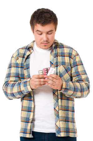 Depressed young man taking pills, isolated on white backgroundの写真素材