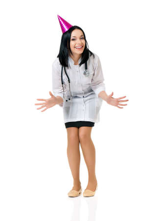 Cheerful young female doctor wearing birthday cap, isolated white backgroundの写真素材