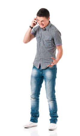 Full length portrait of young man talking on mobile, isolated on white backgroundの写真素材