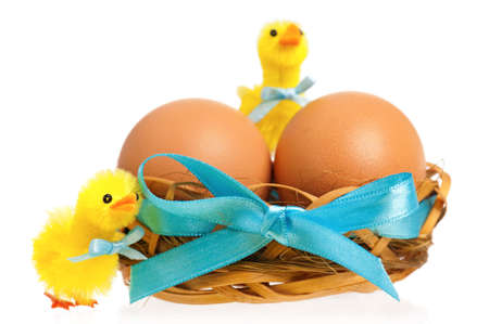 Two little toy chickens and nest with eggs, isolated on white backgroundの写真素材