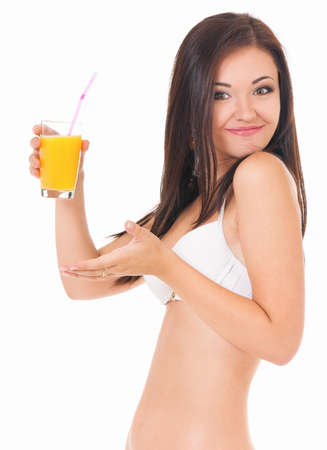 Pretty girl posing in bikini, drink orange juice, isolated on white backgroundの写真素材