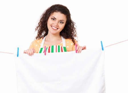 Young housewife hanging clothes on the line, isolated on white backgroundの写真素材