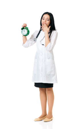 Young female doctor holding a green alarm clock, isolated on white backgroundの写真素材