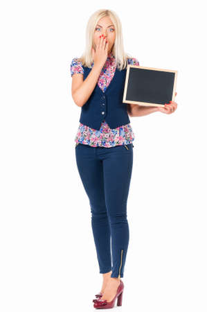 Young shocked woman with small blackboard posing on white backgroundの写真素材