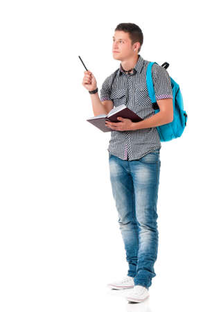 Full length portrait of a caucasian guy carrying some books and a backpack, isolated on white background. Smart  student of college or university writes in a notebook lecture.の写真素材